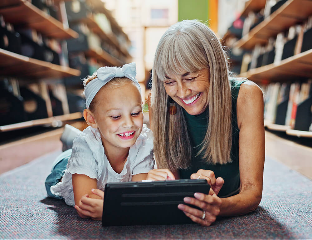 Happy older woman reading a book with a child