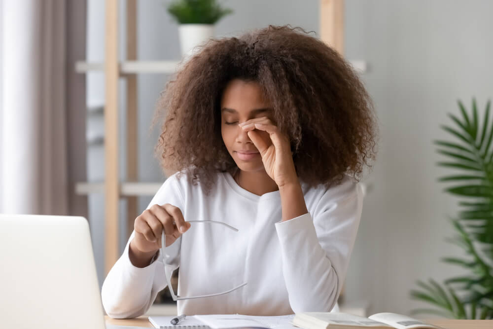 Woman rubbing eyes in pain