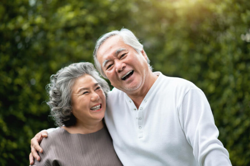 Senior Couple in casual laughing over green nature at park outdoor
